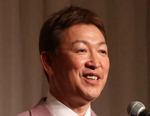 マイクを手に笑顔で話す男性