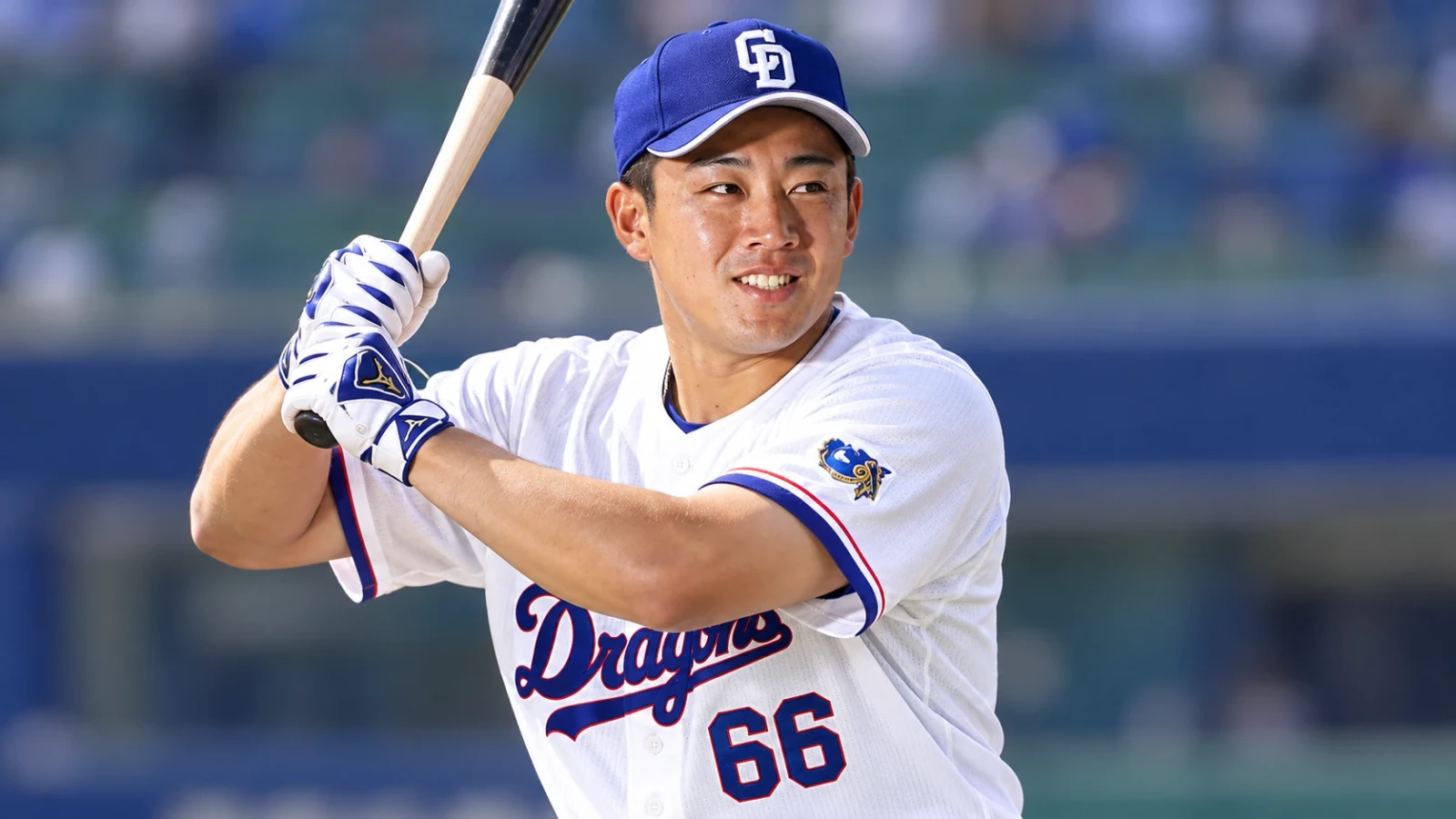白いユニフォームと青い帽子の野球選手が、バットを構えている。